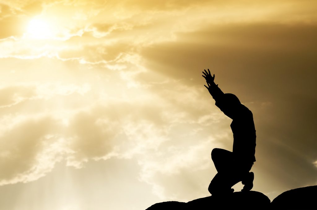 praying man on beautiful sky background